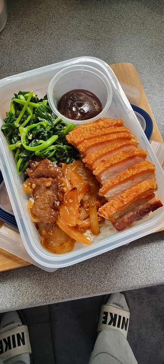 Lunchbox with fried pork, spinach, and rice